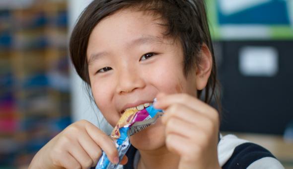 Boy with snack inside a classroom