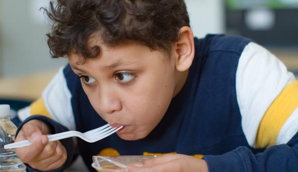 Boy eating fruit cup