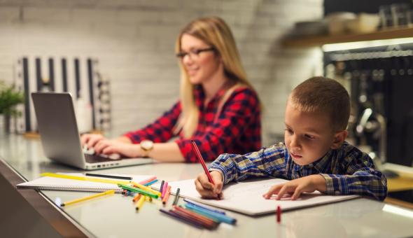 Boy colors while mom works on laptop