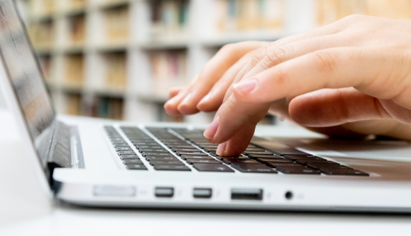Hands typing on laptop keyboard