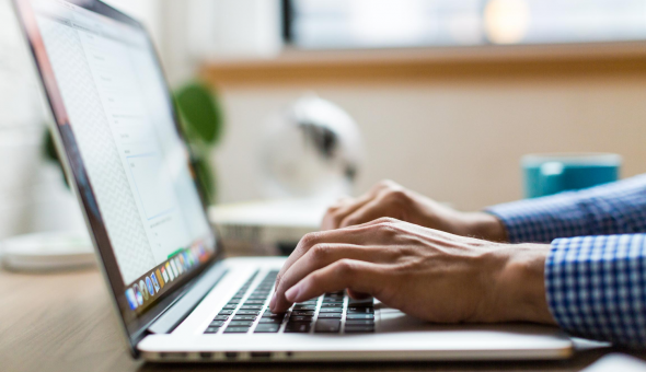 Hands typing on laptop keyboard