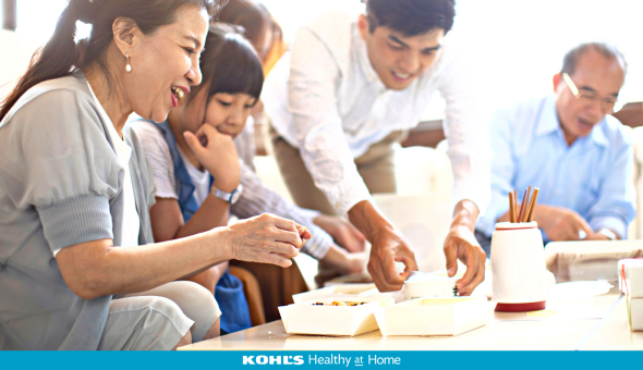 Multigenerational family is excited to try new foods in take-out boxes on the table with a crock of chopsticks
