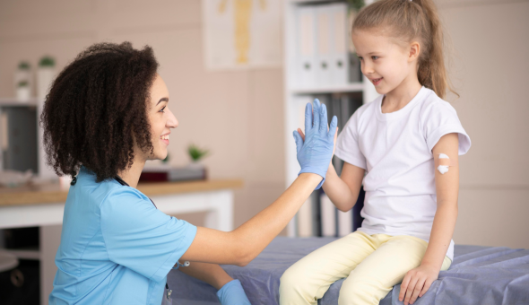 Doctor high fives girl after vaccination