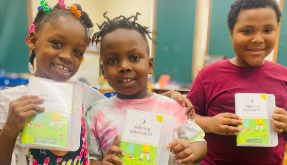Students show materials from The Walking Classroom
