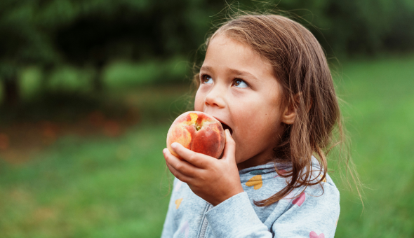 Girl eating peach