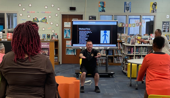 Coach Brian Baumgardner leads a staff wellness workout.